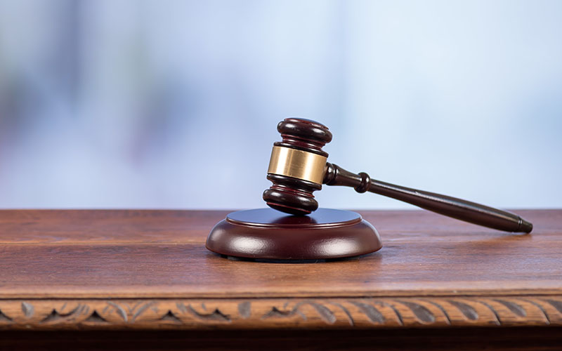 Judge hammer on an old desk on blurred background